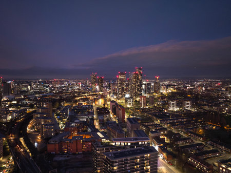 A stunning view of Manchester's skyline, featuring Deansgate Square at dusk, displaying a vibrant urban cityscape illuminated with lights, showcasing the dynamic and modern architectural outlines of the city.の写真素材