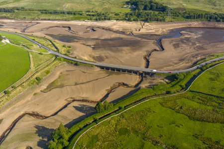 Aerial view of a dramatically low Woodhead Reservoir during drought conditions, The reservoir, part of a system supplying drinking water to Greater Manchester, lies in North Derbyshire, June 2025の写真素材