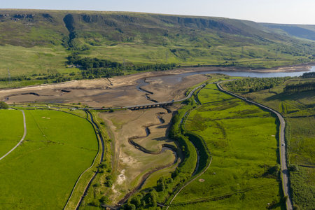 Aerial view of a dramatically low Woodhead Reservoir during drought conditions, The reservoir, part of a system supplying drinking water to Greater Manchester, lies in North Derbyshire, June 2025の写真素材