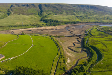 Aerial view of a dramatically low Woodhead Reservoir during drought conditions, The reservoir, part of a system supplying drinking water to Greater Manchester, lies in North Derbyshire, June 2025の写真素材