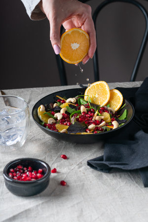 Female hands adding olive oil to fresh vegetable salad, vegetarian lifestyleの写真素材