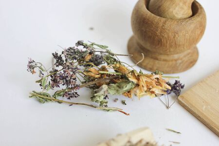 dry flowers on a white background, a derailleur mortar in the background, medicinal herbsの写真素材