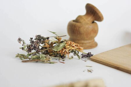 dry flowers on a white background, a derailleur mortar in the background, medicinal herbsの写真素材