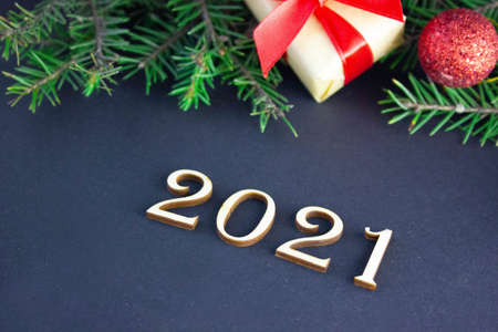 new year layout on dark background with fir branches, inscription from wooden numbers 2021の写真素材