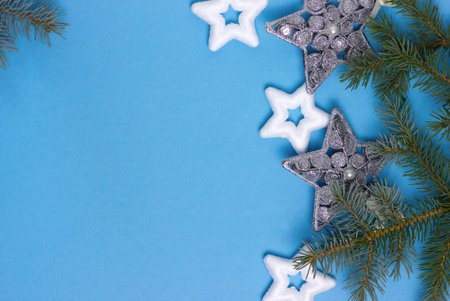 christmas background with stars on a blue background with fir branches, delicate christmas card