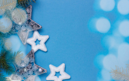 christmas background with stars on a blue background with fir branches, delicate christmas card