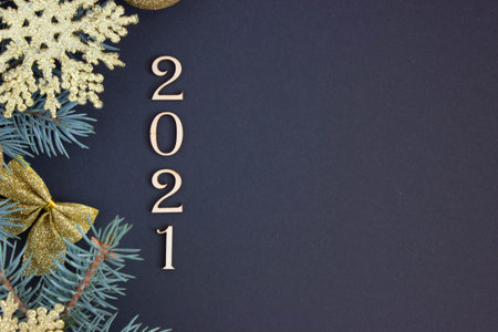 New Year card 2021, New Years decoration from golden Christmas tree decorations and fir branches on the left side on a dark backgroundの写真素材