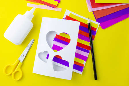 DIY step 7, step-by-step instructions for a paper card for mothers holiday, valentines day, heart made of multi-colored stripesの写真素材