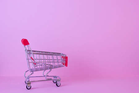 close-up of shopping trolley on pink background with some copy spaceの写真素材