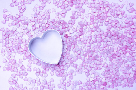 concept of valentines day, mothers day, wedding, delicate pink background of small hearts in metal...