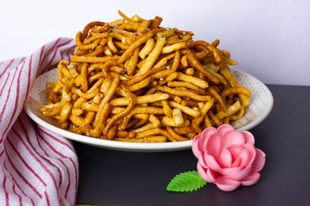 Chak chak stands on the table in a plate next to a red and white napkin. National dish of Tatars and...