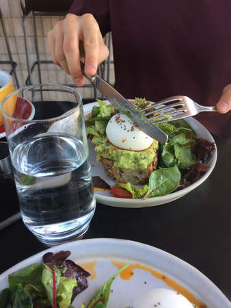 avocado sandwich with egg and red fish in a cafeの写真素材