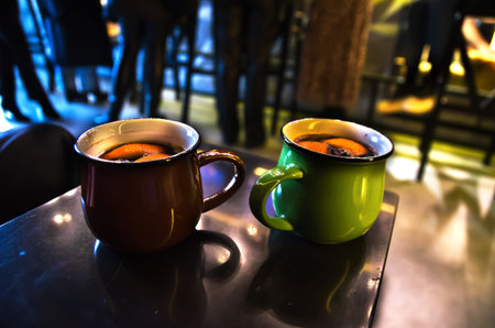 Two mugs with mulled wine on a table in a cinema cafeの写真素材