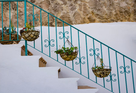 flower pots with flowers are hung on the railing of the stairs there is free space for an inscription.の写真素材