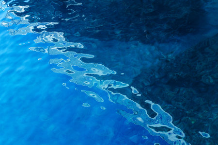 water surface making multiple water circles against blue background beauty product background, water-based concept there is space for textの写真素材
