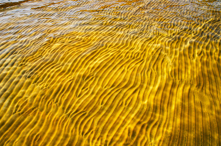 great background whimsical patterns on the sand across the water horizontal orientation good for photo wallpaperの写真素材