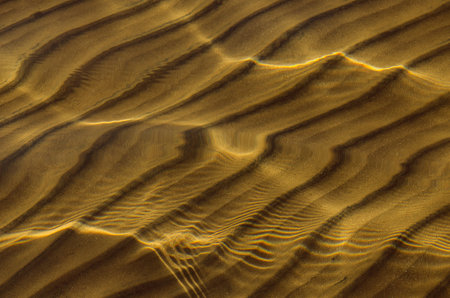 great background whimsical patterns on the sand across the water horizontal orientation good for photo wallpaperの写真素材