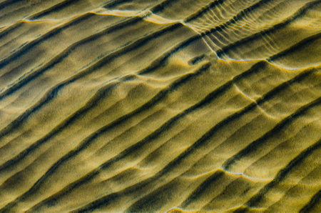 great background whimsical patterns on the sand across the water horizontal orientation good for photo wallpaperの写真素材