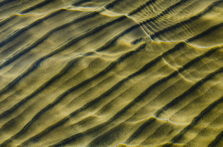 great background whimsical patterns on the sand across the water horizontal orientation good for photo wallpaperの写真素材