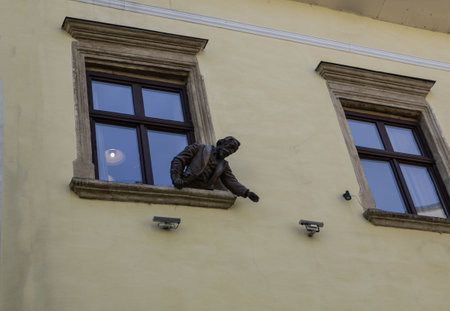 Ukraine Lviv April 28, 2023 sculpture of a man looking out of a windowのeditorial素材