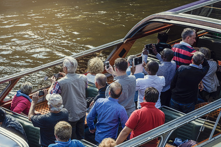 September 14, 2014 Tourists in an open tour boat on the Prinsengracht canal in Amsterdam, The Netherlands.のeditorial素材