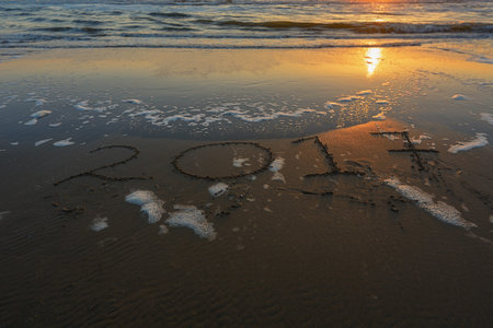 2017 inscription on the sand of evening beach.
