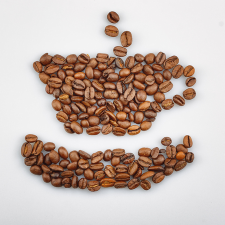 Coffee beans laid out coffee cup and saucer.の写真素材