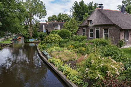 Giethoorn, Netherlands - June 29, 2016: known for its bridges, waterways, 
thatched cottages  and punters. It is also called the 'Dutch Venice' and known to the world Monopoly edition.のeditorial素材
