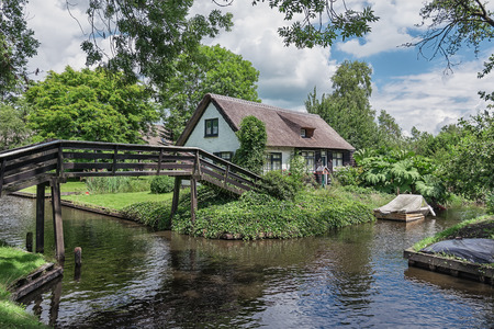 Wooden bridge leading to the house in the Dutch village of Giethoorn.の写真素材