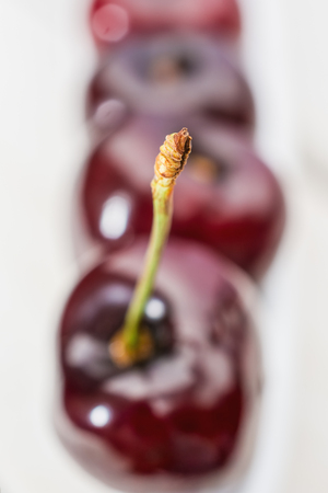 Olive boat filled with cherries on a wooden tableの写真素材