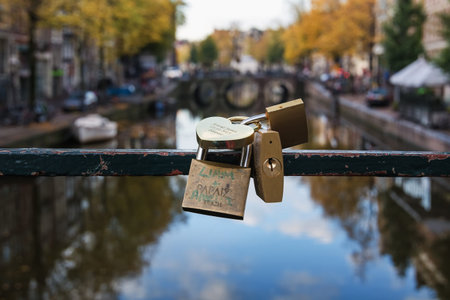 Amsterdam, Netherlands - October 30, 2016: Padlocks attached to a bridge over the canal Oudezijds...