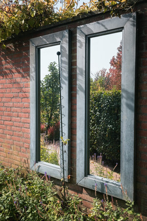 Looking into the two mirrors, one sees the beautiful garden.