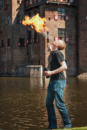 April  19, 2014, Haarzuilens, The Netherlands: Fire spitter at work on the edge of the moat during the Elf Fantasy Fair (Elfia) is an outdoor fantasy event at Castle de Haarのeditorial素材