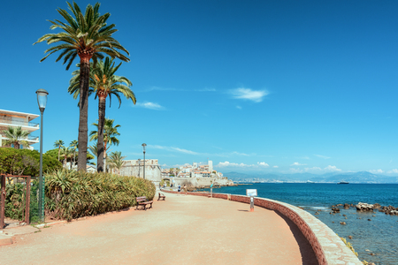 Antibes, France, September 11, 2018:  The pedestrian promenade along the coast of the French town of Antibes with the old city wall and center in the distanceのeditorial素材