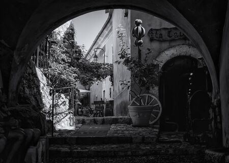 Eze, France, September 5, 2018:  Black and white photo  of the entrance to the La Caverne restaurant in a narrow street in the old center of the  picturesque medieval village of Ezeのeditorial素材