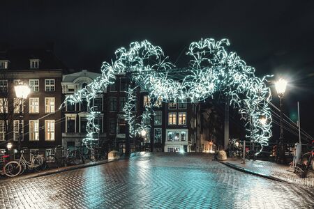 Amsterdam, Netherlands - January 14, 2019: Light Festival Amsterdam, Giant spider of white light above a bridge over the Herengracht in the old town of Amsterdamのeditorial素材