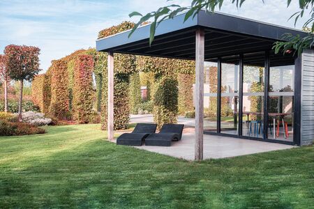 Appeltern, Netherlands, September 29, 2017: two black loungers under an overhang to enjoy the sun in the beautiful autumn gardenのeditorial素材