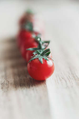 Seven micro tomatoes in a row on a wooden table in The Netherlandsの写真素材