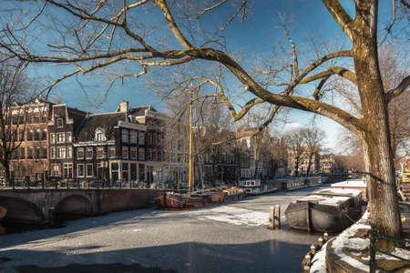 Amsterdam, Netherlands, February 12, 2021: View of the frozen canals in the old center of Amsterdam.のeditorial素材