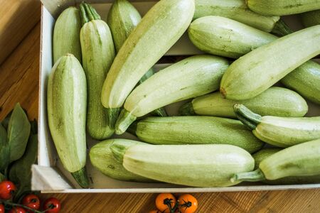 Organic zucchini and tomato in box. Fresh farm products.の写真素材