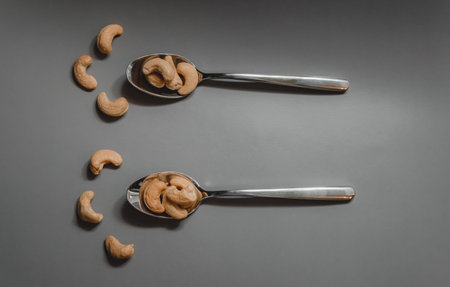 isolated nuts and spoons on a gray plain background