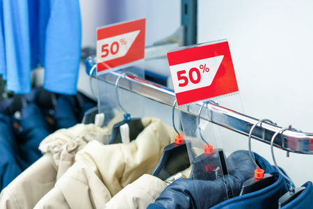 Sale sign 50 percent in a fashion clothes shop display window