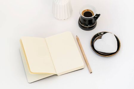 Valentine's Day composition. Female desktop with cup of coffee and plate with heart shaped ginger cookie on white background. Valentines Day celebration conceptの写真素材