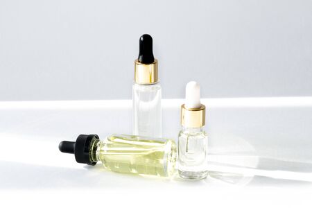Anti aging serum with collagen and peptides in glass bottles with dropper on white background with shadows. Anti-age product, luxury body care and organic science concept.の写真素材