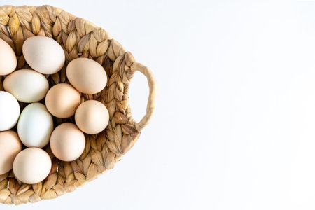 Fresh raw farm organic chiken eggs in a basket on whita background. Natural healthy food and organic...