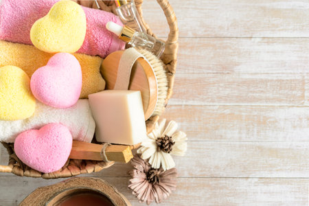 Relaxing bath accessories with yellow and pink heart shaped bath bombs, body brush, serum, palo...
