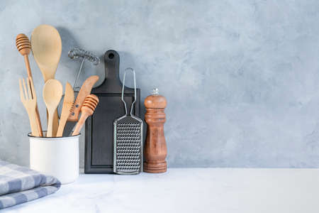 Stylish kitchen background with kitchen utensils on marble countertop, empty space for text, front view. Minimal cooking space with tableware.の写真素材