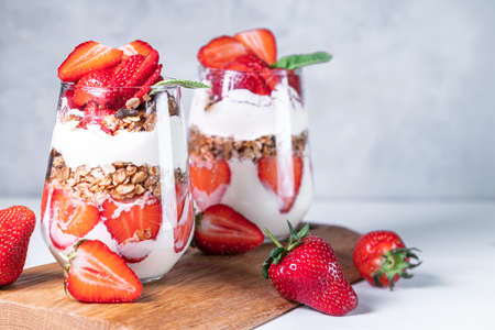 Healthy breakfast of strawberry parfaits made with fresh strawberry, yogurt and muesli in glasses.の写真素材