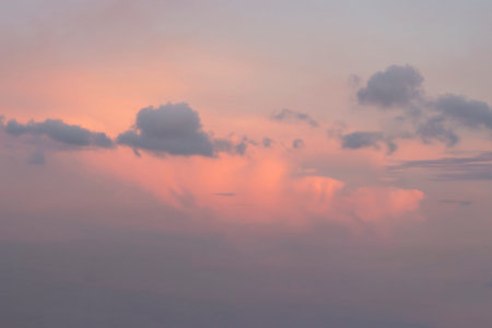 Sky with gray cumulus and layer clouds against orange sunset. Nature background.