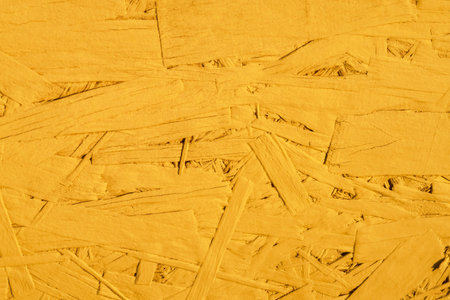 Colored OSB construction material. Chipboard composed of compressed wooden stuff. yellow abstract...